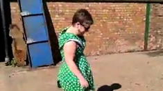 Flashing in green dress and white stilettos